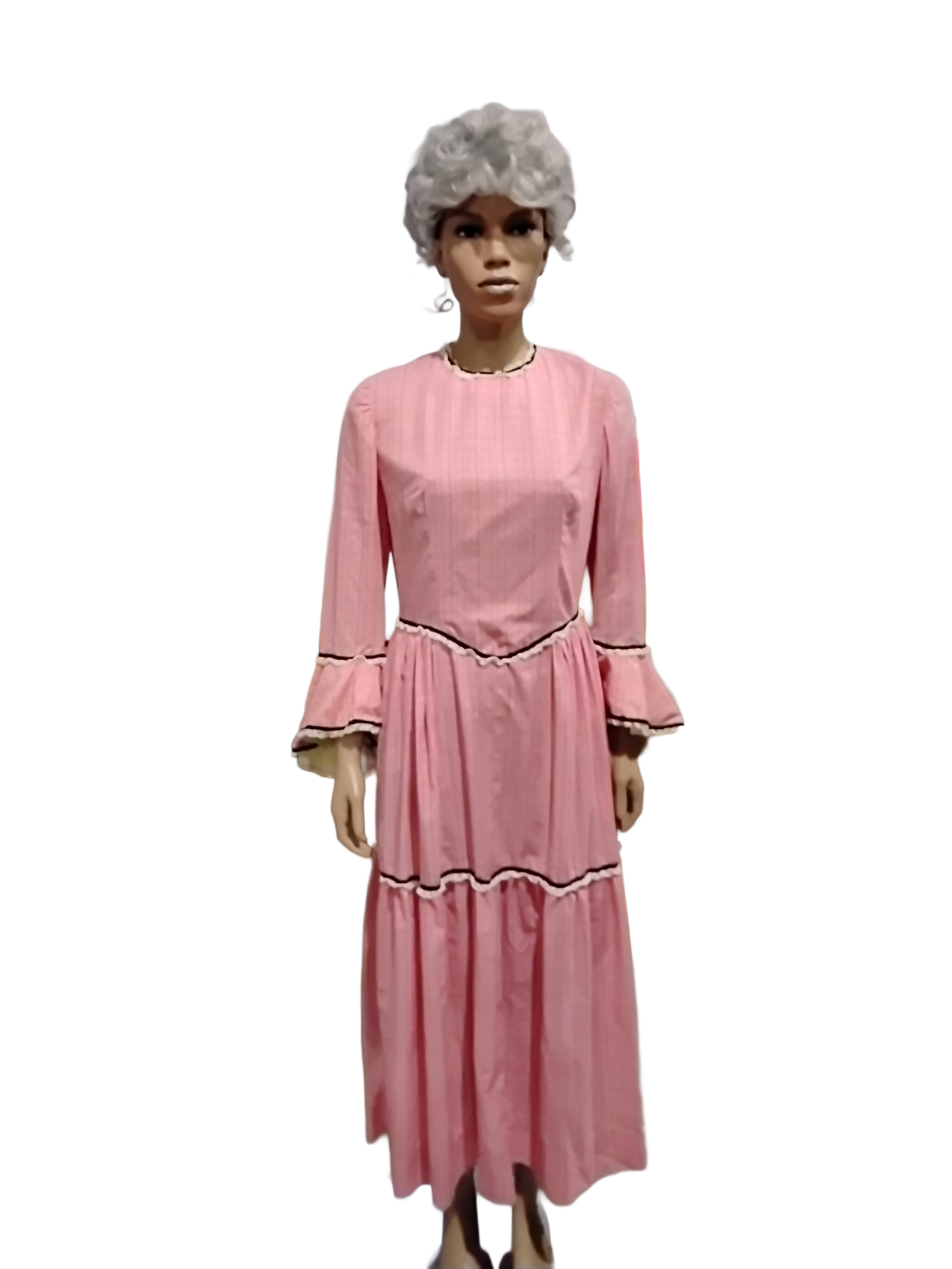This garment is ideal for a wide range of stage roles, period plays, and character protrayals including: Theatrical productions: Excellent for Little House on the Prairie, Oklahoma, The Music Man, Our Town or Western stage plays Period Roles: Pioneer schoolteacher, frontier townsperson or Victorian country village character Events & Pageants: Pioneer Day reenactments, historical museum presentations, living history events, and themed photoshoots. Design & Style Silhouette: Victorian/Pioneer inspired maxi dress with a dropped waist and gathered tiered skirt. Sleeves and Neckline: High modest neckline with piping detail and long bell/trumpet sleeves. Fabric and pattern: Soft coral mini-gingham check. Accents: Dark scalloped rickrack trim accenting the bodice, sleeve cuffs, and lower skirt ruffles. This garment is ideal for a wide range of stage roles, period plays, and character protrayals including: Theatrical productions: Excellent for Little House on the Prairie, Oklahoma, The Music Man, Our Town or Western stage plays Period Roles: Pioneer schoolteacher, frontier townsperson or Victorian country village character Events & Pageants: Pioneer Day reenactments, historical museum presentations, living history events, and themed photoshoots. Design & Style Silhouette: Victorian/Pioneer inspired maxi dress with a dropped waist and gathered tiered skirt. Sleeves and Neckline: High modest neckline with piping detail and long bell/trumpet sleeves. Fabric and pattern: Soft coral mini-gingham check. Accents: Dark scalloped rickrack trim accenting the bodice, sleeve cuffs, and lower skirt ruffles.
